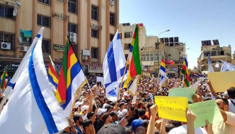 شهدت محافظة السويداء، يوم السبت 16 آب/ أغسطس، توافد مئات الأشخاص إلى ساحة الكرامة وعدة ساحات رئيسية في بلدات وقرى المحافظة، حيث رُفعت شعارات تطالب بما سُمّي "حق تقرير المصير والاستقلال"، إلى جانب أعلام الطائفة الدرزية وأخرى للاحتلال الإسرائيلي، في سابقة أثارت جدلاً واسعاً وانتقادات حادة. وأكد منظمو الحراك أنه يأتي تعبيراً عن "وحدة الموقف الشعبي"، غير أن مصادر ميدانية ومراقبين رأوا أن بعض الشعارات المرفوعة تحمل طابعاً انفصالياً مشبوهاً، يسعى إلى عزل السويداء عن محيطها السوري وتعزيز الانقسام الداخلي. ورُصد في المظاهرات شعارات رافضة للحكومة السورية، تصفها بأنها "سلطة أمر واقع"، إلى جانب مطالب بفتح معبر إنساني عاجل، وتشكيل لجنة تحقيق دولية، والإفراج عن المعتقلين. كما حيّا المتظاهرون شيخ الطائفة حكمت الهجري، فيما رفع بعض المشاركين لافتات كتب عليها "الانفصال ولا العيش في دولة الإرهاب"، مع توجيه شكر علني لإسرائيل. في موازاة ذلك، استمرت قوافل المساعدات الإنسانية بالدخول إلى المحافظة عبر معبر بصرى الشام، بإشراف الهلال الأحمر السوري وبالتنسيق مع برنامج الغذاء العالمي. وتزامنت المظاهرات مع حوادث إطلاق نار متفرقة في ريفي السويداء ودرعا، بينها هجوم استهدف سيارة مدنية قرب بلدة كحيل، أودى بحياة امرأة وألحق أضراراً مادية بحافلتين، فيما أعلنت الجهات المختصة متابعة التحقيق في الحادثة. ويرى مراقبون أن رفع أعلام الاحتلال الإسرائيلي في المظاهرات يُمثل انزياحاً خطيراً عن مطالب الإصلاح والمعيشة التي عُرفت بها احتجاجات السويداء خلال الأشهر الماضية، ويحمل دلالات سياسية قد توظفها أطراف خارجية لتأجيج الانقسامات وضرب النسيج الوطني السوري.