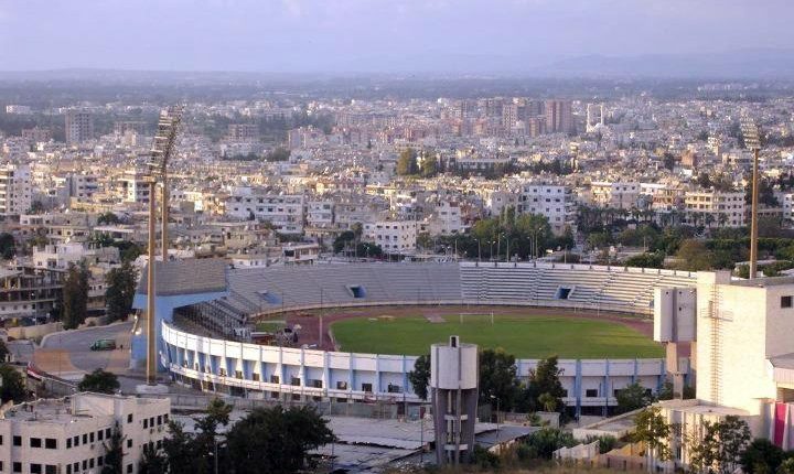 بين أزمات معيشية خانقة وواقع يطغى عليه العنف في أكثر من منطقة سورية، فقد كثيرون شغفهم بالرياضة، إلا أن آخرين ما زالوا يتمسكون بكرة القدم باعتبارها القاسم المشترك القادر على جمع السوريين على اختلاف توجهاتهم وانتماءاتهم. اليوم تتجه الأنظار إلى انتخابات مجلس إدارة اتحاد كرة القدم السوري، بعد أن استُنفدت كل المهل القانونية الممنوحة من الاتحاد الدولي لكرة القدم (فيفا) لإنهاء حالة الفراغ الإداري المستمرة منذ استقالة مجلس الإدارة السابق مطلع يناير/ كانون الثاني الماضي، وسط أجواء يطغى عليها التفاؤل الحذر. دور الوزارة وتدخلات مثيرة للجدل وزارة الرياضة والشباب، عبر لجنتها الاستشارية التي تدير اللعبة مؤقتاً، تسعى إلى ضبط مسار الانتخابات ومنع عودة الوجوه التقليدية لإدارة الاتحاد، وذلك من خلال تعديلات مقترحة على النظام الأساسي تسمح بترشح شخصيات لا تنطبق عليها الشروط السابقة. أبرز هذه التعديلات يتمثل في إلغاء شرط المؤهل العلمي للمرشحين لرئاسة الاتحاد أو عضويته، ما أثار جدلاً واسعاً في الشارع الرياضي والإعلامي. ويرى معارضون للتعديل أنه يشكّل تراجعاً عن معايير الكفاءة والخبرة التي تحتاجها اللعبة في ظل التطور الكبير آسيوياً وعالمياً. أسماء تعلن نيتها الترشح رغم غياب التعليمات الرسمية حتى الآن، بدأ بعض الأسماء البارزة بالإعلان عن نيتها الترشح. من بينهم الحكم الدولي السابق فراس الخطيب (المقيم في هولندا)، والإداري السابق أحمد بيطار (المقيم في الولايات المتحدة)، إضافة إلى نائب رئيس الاتحاد السابق تاج الدين فارس. وقد طرح هؤلاء ملامح أولية لبرامجهم الانتخابية، مع وعود بإصلاحات وتطوير للعبة. جدل حول نظام القوائم من بين المقترحات أيضاً اعتماد نظام القوائم الانتخابية بدلاً من الانتخابات الفردية للرئيس ونائبه والأعضاء. هذا النظام يَعِد بانسجام أكبر بين مكونات مجلس الإدارة الجديد، لكنه في المقابل قد يُقصي أسماء كفوءة. التجربة السابقة في اتحاد كرة السلة السوري أثارت الشكوك حول هذا النظام، إذ قادت إلى تركيز السلطة بيد الرئيس من دون معارضة تُذكر. ووفقاً للتسريبات، سيُخفض عدد أعضاء مجلس الإدارة الجديد من 11 إلى 9، مع مراعاة التوزع الجغرافي، من دون شرط أن يكون الرئيس مقيماً في دمشق كما كان معمولاً به سابقاً. ملاحظات "فيفا" وملف الولاية الجديدة الاتحاد الدولي لكرة القدم قدّم ملاحظات على التعديلات المطروحة، خصوصاً بشأن مدة ولاية المجلس الجديد. فبينما تقترح التعديلات اعتماد ولاية كاملة لأربع سنوات حتى 2029، يربط "فيفا" الأمر بالمرحلة الانتقالية التي مرّ بها الاتحاد بعد الاستقالة. ومع ذلك، فإن طول فترة الفراغ الحالي دفع "فيفا" إلى الميل نحو منح ولاية جديدة كاملة لتحقيق الاستقرار وإتاحة الوقت لتسريع العمل. تحديات متراكمة أمام المجلس الجديد مهما كانت هوية الفائزين في الانتخابات المقبلة، فإن التحديات أمامهم كبيرة ومعقدة. البنية التحتية الرياضية المتهالكة، والموارد المالية المحدودة، والقوانين التي تمنع الأندية من إدارة استثماراتها بحرية، كلها عقبات ما زالت قائمة. فالأندية السورية توصف بأنها "محترفة بالاسم فقط"، بينما تدار عملياً كأندية هاوية. إلى جانب ذلك، فإن التأخر في تحديد موعد الانتخابات يعني أن المجلس الجديد لن يتسلم مهامه قبل نهاية أكتوبر/ تشرين الأول، أي مع انطلاق الموسم الكروي المحلي والخارجي. هذا الواقع سيجبر الاتحاد الجديد على الانخراط مباشرة في إدارة الروزنامة الكروية المزدحمة، بدلاً من التفرغ لترتيب البيت الداخلي أو إطلاق خطط تطويرية بعيدة المدى. بين الأمل والقلق الانتخابات المرتقبة لاتحاد كرة القدم السوري تحمل في طياتها آمالاً بتجديد الدماء وتحقيق انطلاقة مختلفة، لكنها في الوقت ذاته محفوفة بمخاطر استمرار الأزمات الإدارية والمالية والتنظيمية. وبين شد وجذب داخلي وضغوط خارجية من "فيفا"، تبقى كرة القدم السورية أسيرة ظروف معقدة تجعلها تدفع ثمناً باهظاً لتأخير الاستحقاق الانتخابي المنتظر.