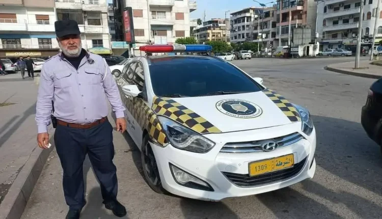تواجه شرطة المرور في دمشق وريفها انتقادات من المواطنين، مع تكرار مواقف تشير إلى ضعف التنظيم والرقابة، وعدم إلمام بعض العناصر بالمهام الأساسية المرتبطة بعملهم، في وقت تعلن فيه إدارة المرور أن النقص في الكوادر هو أبرز التحديات التي تواجهها. ملاحظات على أداء العناصر رصدت مشاهد في وسط دمشق أظهرت أن بعض العناصر الجدد يفتقرون للمعرفة بخريطة المواقع الرسمية والأماكن العامة في القطاعات المفرزين إليها. وفي واقعة أخرى، لم يتمكن ركاب حافلة من الحصول على مساعدة أحد عناصر المرور بعد خلاف حول الأجرة مع السائق، إذ اعتذر الشرطي بحجة أن مكان الشكوى خارج نطاق خدمته، رغم وجوده قريبًا من الموقع. تثير هذه الحوادث تساؤلات حول اقتصار عمل شرطة المرور على الوجود الشكلي في الشوارع، مقابل غياب الدور الفعلي في الرقابة وتقديم الخدمة للمواطنين. توزيع العناصر والأماكن المزدحمة مدير إدارة المرور في سوريا، العميد فادي الهميش، أوضح أن عدد عناصر المرور في دمشق يبلغ نحو 800 عنصر موزعين على ثمانية قطاعات، بالإضافة إلى ضباط جولة، ومفرزتي الروافع والضابطة. أما في ريف دمشق، فيقدَّر العدد بـ250 عنصرًا موزعين على خمسة قطاعات، وتشمل هذه التقديرات الورديات الثلاث اليومية. وأكد الهميش أن الأولوية في التوزيع تُمنح للمناطق المزدحمة والساحات المرورية الكبرى، فيما تخصص عناصر أخرى للدوارات والإشارات الأقل أهمية. وأضاف أن بعض النقاط تحتاج أكثر من عنصر واحد بسبب شدة الازدحام والانقطاعات المتكررة للتيار الكهربائي التي تعطل الإشارات الضوئية. رد الإدارة على الانتقادات وحول عدم معرفة بعض العناصر بالتفاصيل الجغرافية للمناطق التي يخدمون بها، أرجع الهميش ذلك إلى أن معظمهم ليسوا من أبناء المحافظة، وإلى التنقل المستمر بين النقاط نتيجة قلة العدد، ما يجعل معرفتهم مقتصرة على الشوارع الرئيسية والأماكن العامة. وأشار إلى إمكانية تنظيم دورات تثقيفية لتعريف العناصر بالمباني الرسمية والأماكن الحيوية والسياحية، أو تجهيز النقاط المرورية بخرائط تفاعلية تساعدهم في أداء مهامهم. أما بخصوص ترك بعض العناصر مواقعهم، فرأى أن ضبط الالتزام يتطلب زيادة عدد الضباط المكلفين بالجولات الميدانية أو تعيين مراقبين لكل قطاع، وهو أمر يصعب تنفيذه حاليًا. وأضاف: “العناصر في النهاية بشر، يحتاجون إلى فترات للراحة أو الصلاة أو قضاء حاجاتهم”، والحل برأيه يكمن في زيادة عدد العناصر بكل نقطة لضمان التناوب دون تعطيل العمل. الحاجة لاستقطاب كوادر إضافية لفت مدير إدارة المرور إلى أن تحسين الأجور وتقليص ساعات العمل وتشجيع عودة العناصر القدامى للخدمة، عوامل أساسية لزيادة الكادر. وأكد أن العناصر السابقين الذين عادوا ساهموا في رفع مستوى الانضباط والأداء، موضحًا أن تقييم عملهم كان “جيدًا إلى جيد جدًا”. وكان معاون وزير الداخلية في الحكومة المؤقتة السابقة، شادي اليوسف، قد صرح في وقت سابق بأن الوزارة اختارت مجموعة من العاملين السابقين بشرطة المرور، بعد إجراء مقابلات وتزويدهم بتعليمات صارمة بخصوص الالتزام بالنظام العام وحسن التعامل مع الناس. وأكد أن الوزارة ستتخذ إجراءات مشددة بحق أي تجاوزات تصل إلى حد الفصل من الخدمة. قنوات تواصل مع المواطنين تتيح وزارة الداخلية الرقم “115” للتواصل المباشر في الحالات الطارئة، إلى جانب الوجود الميداني لعناصر المرور في الشوارع للتعامل مع شكاوى المواطنين، في محاولة لتقليل الفجوة بين الناس والجهات المسؤولة عن تنظيم السير.