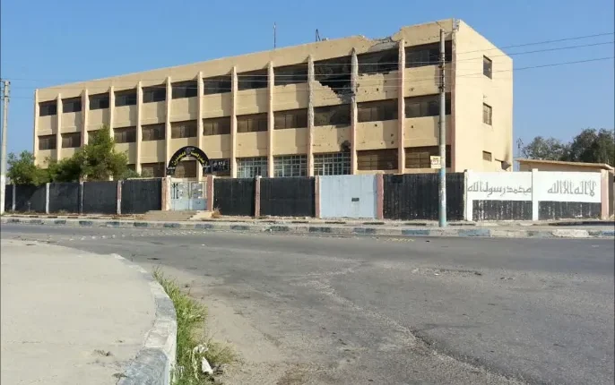 يواجه أكثر من 40 ألف طالب في مدينة الرقة خطر الحرمان من التعليم مع اقتراب بدء العام الدراسي الجديد، بسبب استمرار إغلاق 35 مدرسة في المدينة. المدارس المغلقة جاهزة لاستئناف النشاط التعليمي، إلا أن تواجد عائلات نازحة داخل الأبنية، حيث يسكن كل مبنى نحو خمس عائلات، يحول دون ذلك ويزيد من معاناة الطلاب وأسرهم. وبرغم عودة بعض النازحين إلى قراهم الأصلية، يبقى عدد كبير منهم في المدارس، ما يعيق إعادة فتحها وتمكين الأطفال من العودة إلى صفوفهم الدراسية. ويرى مسؤولون محليون أن الوضع تعقد أكثر بسبب مشاركة بعض الأطفال النازحين المنتسبين لـ"الشبيبة الثورية" التابعة لقوات سورية الديمقراطية في أنشطة غير قانونية، مثل السرقات الليلية وإقامة الحواجز في أحياء المدينة، ما يزيد المخاطر الأمنية في محيط المدارس. ورغم استمرار العائلات النازحة في تلقي مساعدات شهرية بقيمة 130 دولارًا، إضافة إلى سلال غذائية، لم تُسهم هذه التدابير في حل أزمة الإغلاق أو إعادة الطلاب إلى مقاعدهم الدراسية. قائمة المدارس المغلقة في الرقة: أبي تمام عمر بن عبد العزيز أبو بكر الرازي عبد الله الحسن أبو جعفر المنصور الفارابي مصعب بن عمير الأمين فاطمة الزهراء الحسن بن الهيثم معاوية بن أبي سفيان موسى بن نصير الأندلس (ابتدائي) السباية الشرقية زكي الأرسوزي ابن البيطار الانتفاضة نيسان الرافقة البتاني سكينة رابعة العدوية عمار بن ياسر ملحق عمار وتبقى مسألة إعادة فتح المدارس وتوفير بيئة تعليمية آمنة ومستقرة للطلاب من أبرز التحديات التي تواجه السلطات المحلية والأسر، وسط غياب حلول واضحة أو خطوات عملية لإعادة الحياة التعليمية إلى طبيعتها في الرقة.