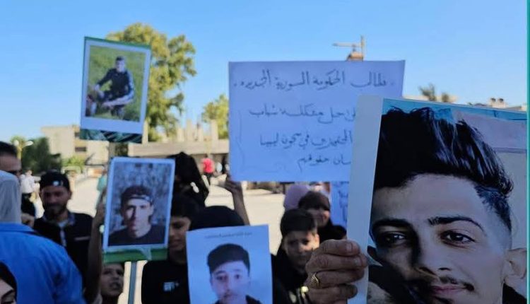 ناشد عشرات الأهالي في محافظة درعا الحكومة السورية التحرك العاجل لكشف مصير أبنائهم المحتجزين في ليبيا منذ عدة أشهر، والعمل على إعادتهم إلى البلاد، بعد أن فُقد الاتصال بهم خلال محاولاتهم الوصول إلى أوروبا عبر طرق الهجرة غير النظامية. جاءت المناشدة خلال وقفة احتجاجية نظمها الأهالي اليوم، الأربعاء، رفعوا فيها لافتات تطالب الحكومة بتحمل مسؤولياتها الإنسانية والقانونية تجاه المفقودين، والتواصل مع السلطات الليبية لتوضيح أوضاعهم وظروف احتجازهم. وقال أحد المشاركين في الوقفة ويدعى فيصل، إن لديه أقارب بينهم نساء وأطفال محتجزون منذ نحو عام داخل سجون تابعة للحكومة الليبية، بعد أن تم توقيفهم خلال رحلة الهجرة، مشيراً إلى أن من بين المعتقلين أربعة شبان من قرية محجة لا تتجاوز أعمار ثلاثة منهم 17 عامًا. ووجه الأهالي نداءً مشتركًا عبر اللافتات قالوا فيه: «ساعدونا بالعثور على أولادنا المفقودين في سجون ليبيا، هربوا من القسوة والظلم ليبحثوا عن مستقبل أفضل، لكنهم وقعوا ضحية المهربين والابتزاز». ورغم أن معظم المحتجزين ينحدرون من درعا، فإن معلومات متقاطعة تؤكد أن الموقوفين السوريين في ليبيا يتوزعون على مختلف المحافظات السورية، وقد لجأوا إليها خلال السنوات الماضية بحثًا عن طريق للوصول إلى أوروبا. إحدى القصص التي تسلّط الضوء على خطورة طريق الهجرة إلى أوروبا رواها الشاب "فايز" (اسم مستعار) من ريف اللاذقية، الذي غادر إلى ليبيا منتصف عام 2024 مع صديقه، بعد أن دفع كل منهما 10 آلاف دولار أميركي للمهربين مقابل الوصول إلى إيطاليا. وقال فايز في حديثه لموقع سناك سوري إنه وصل إلى ليبيا بطريقة قانونية وأقام في فندق بانتظار موعد الرحلة البحرية، لكن الأشهر مرّت دون أي نتيجة. لاحقًا أبلغهم المهرب أن وقت الرحلة قد حان، فانتقلوا مع مجموعة من المهاجرين تحت إشراف مسلحين، قبل أن يتعرضوا لعملية اختطاف وسرقة شملت الأموال والهواتف وحتى الملابس. وأضاف أن صديقه تمكن من الفرار لاحقًا بمساعدة مهرب آخر بعد دفع 4000 يورو إضافية، ونجح في الوصول إلى إيطاليا ومنها إلى ألمانيا. إلا أن فايز نفسه ظل محتجزًا فترة طويلة قبل أن يفرج عنه. وأوضح أن صديقه يفكر اليوم بالعودة إلى سوريا بعد أن فشلت محاولاته في الحصول على اللجوء في أوروبا عقب سقوط النظام السوري أواخر عام 2024. وبحسب تقديرات منظمات إغاثية محلية غير رسمية، يتواجد في ليبيا ما بين 30 و50 ألف سوري، كثير منهم وصلوا بعد عام 2011 بحثًا عن فرص عمل أو طريق نحو الهجرة. وفي أيار الماضي، أعلن وزير الخارجية السوري أسعد الشيباني عن قرار فتح سفارة وقنصلية سورية في ليبيا لتقديم الخدمات القنصلية لأبناء الجالية السورية وتعزيز العلاقات الثنائية بين البلدين، في خطوة يأمل الأهالي أن تساهم في كشف مصير أبنائهم وإعادتهم إلى وطنهم بأقرب وقت.